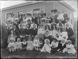 Large unidentified wedding group outside a wooden building, probably Christchurch district