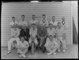 Large group of unidentified men's cricket team, in front of a wooden building, probably Christchurch district