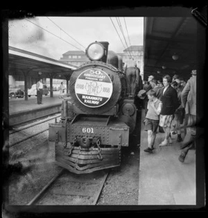 A steam train, at Wellington Railway Station, on the occaision of the 50th anniversary of the Manawatu Railway, including unidentified people on platform alongside