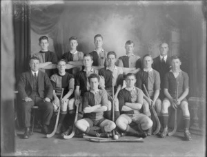 Studio portrait of unidentified men's hockey team and coaches, probably Christchurch district, includes hockey sticks and ball in front