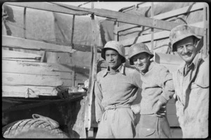 New Zealanders in German helmets beside truck shot up by anti tank gun, Tobruk, World War II