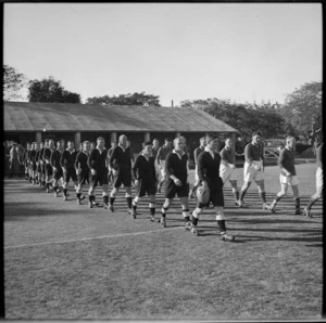 NZEF and South African rugby teams march onto the field at Cairo, Egypt