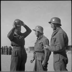 NZ former prisoners trying out German hats at NZ Base Camp, Egypt - Photograph taken by M D Elias