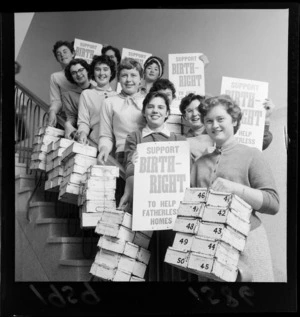 Women hold up posters and collection boxes during a public appeal to support Birthright New Zealand