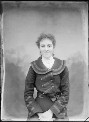 Portrait of an unidentified woman seated outdoors, with painted studio backdrop, probably Christchurch district