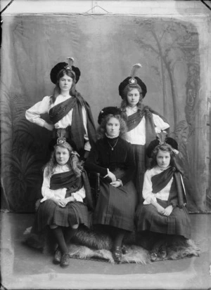 Studio portrait of five unidentified young ladies, four wearing traditional Scottish national costume, including ghillies, tartan skirts, and sashes