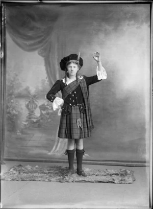 Studio portrait of an unidentified Highland dancer, showing a girl wearing traditional Scottish costume