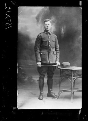 Studio portrait of an unidentified man wearing a military uniform with jodhpurs, possibly Christchurch