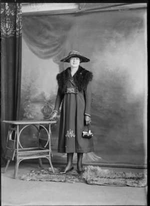 Studio portrait of an unidentified woman wearing a fur tippet, and holding a small handbag, possibly Christchurch