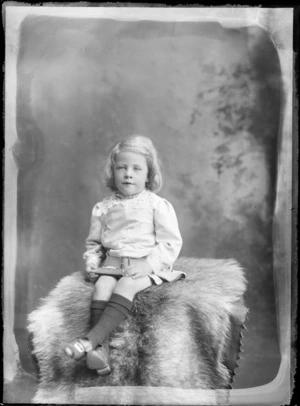 Studio portrait of an unidentified child, wearing a tunic with a lace collar, possibly Christchurch district