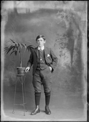 Studio portrait of an unidentified boy, wearing knee-breeches, waistcoat and jacket, possibly Christchurch district