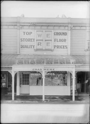 Exterior view of Chas Were butchery, including a reflection of the photographer in the shop window, possibly Christchurch district