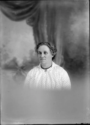 Head and shoulders studio portrait of unidentified mature woman, wearing a beaded necklace, probably Christchurch district