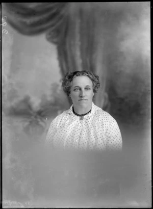 Head and shoulders studio portrait of unidentified mature woman wearing a beaded necklace, probably Christchurch district