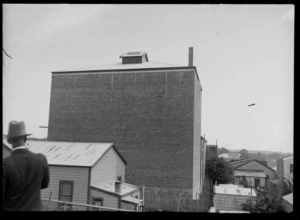 Back end view of Municipal Theatre, Ford Car Dealership and residential buildings beyond after the Hawkes Bay earthquake, Waipukurau, Hawke's Bay District