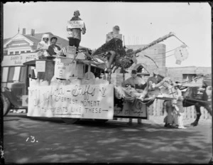 New Napier Week Carnival, men and woman in costumes on a truck with signs 'Slingford-Stiff's, Greatest Moment, It's Moments Like These', with stork and 'baby', doctors & nurses, Napier, Hawke's Bay District