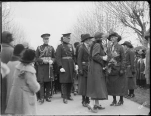 Military officers and women with flowers escorting Lord Bledisloe, the Governor General, people looking on, Hawke's Bay District