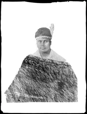 Masked photo of a young Maori woman, with headband and feather wearing a cloak, Hawke's Bay District