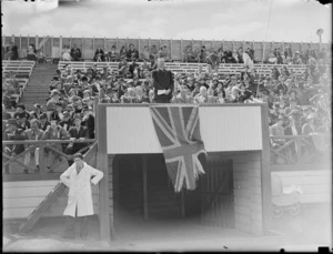 Sir Joseph Ward speaking at an unknown event, including dignataries and crowds of people sitting behind him