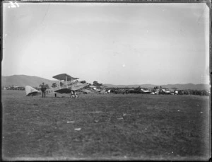 Biplane with G NZAY written on it, including other planes and spectators in the background, probably Hastings district