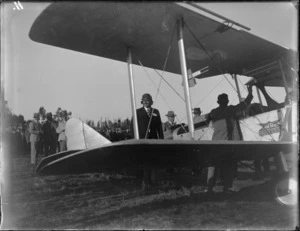 Unidentified pilot and other men stand by biplane with Avro Avian sign, probably Hastings district