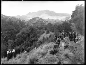 Large group of men and women stopping for a cup of tea on a walking track in the hills, unidentified location