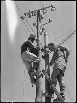 Member of NZ line gang working on overhead line with member of Free French Forces in Syria, World War II - Photograph taken by H Paton