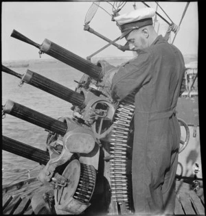 Placing drum of ammo in small AA gun on HMS Leander