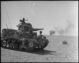 Stuart tank with smoke from burning Messerschmitt 109F in the background, Egypt - Photograph taken by H Paton