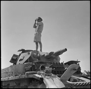 Disabled tank serves as observation post for NZ officer, Egypt - Photograph taken by H Paton