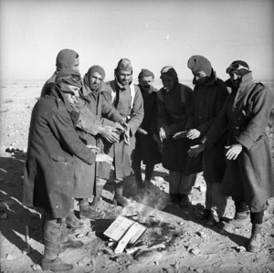 World War II New Zealand soldiers warming their hands by a fire, Western Desert, Egypt