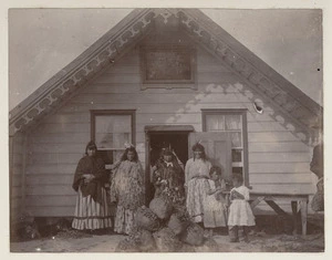 Group of Maori women in front of an unidentified meeting house