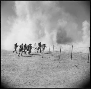 Men passing through gap in barbed wire under cover of dust from a Bangalore Torpedo, Egypt
