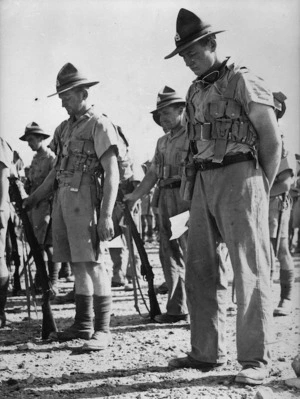 World War II soldiers with their heads bowed in prayer, at an Anzac Day service at El Saff, Egypt