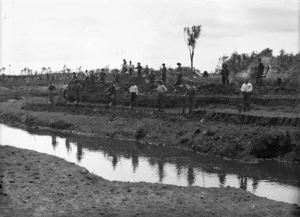 Men with shovels standing by a drainage ditch, Kaitaia