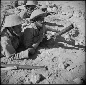 Member of the Maori Battalion using a 2 inch mortar during manoeuvres, Western Desert, Egypt