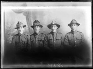 Studio portrait of four unidentified men, wearing military uniforms, possibly Christchurch district
