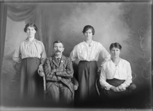 Studio portrait of members of an unidentified family, showing the man, one of the younger women sitting on cane seats, with the two other women standing alongside them, possibly Christchurch district