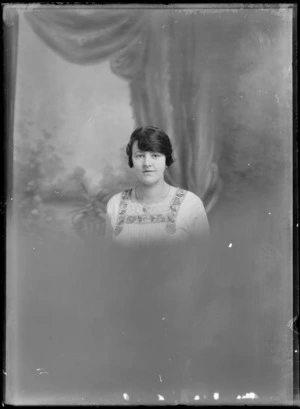 Studio portrait of the upper torso of an unidentified woman wearing a floral embroidered dress, possibly Christchurch district