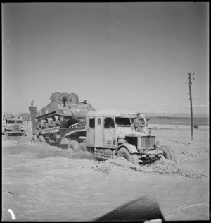 Tank transporter carrying Sherman tank over flooded stream, Tunisia - Photograph taken by M D Elias
