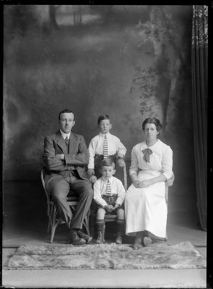 Studio family unidentified portrait, husband and wife with glasses, sitting with young sons dressed identically with shirts and striped ties, and shorts with leather belts, Christchurch