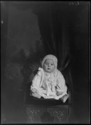 Studio portrait of unidentified baby, wearing a crochet hat and cardigan, probably Christchurch district