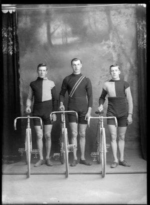 Studio portrait of three unidentified male cyclists, in uniform with racing bicycles, probably Christchurch district