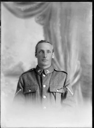 Studio upper torso portrait of unidentified Lance Corporal World War I soldier with [Tui or Huia?] 'NXXIZ' collar badges and dark shoulder webbing attached to left side lapel pocket, Christchurch