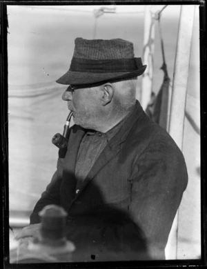 Unidentified man smoking pipe on whaling boat, Bay of Islands, Far North District, Northland Region