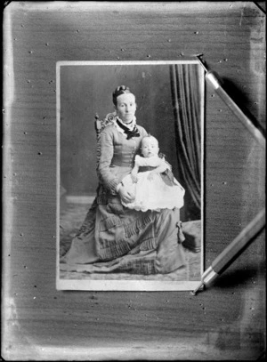 Studio portrait of an unidentified woman holding a baby on her lap, possibly Christchurch district