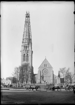 Christ Church Cathedral spire with scaffolding surrounding it, and horses and carts in foreground, Christchurch