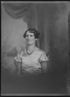 Studio upper torso portrait of an unidentified woman in a satin dress wearing a coloured glass bead necklace, Christchurch