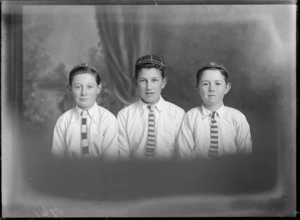 Studio upper torso portrait of three unidentified young boys in caps with 'Avon Rowing Club' badges and striped ties, Christchurch