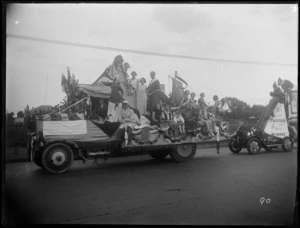 Westerman's float at the Hastings carnival parade carrying a group in costume, Hawke's Bay District